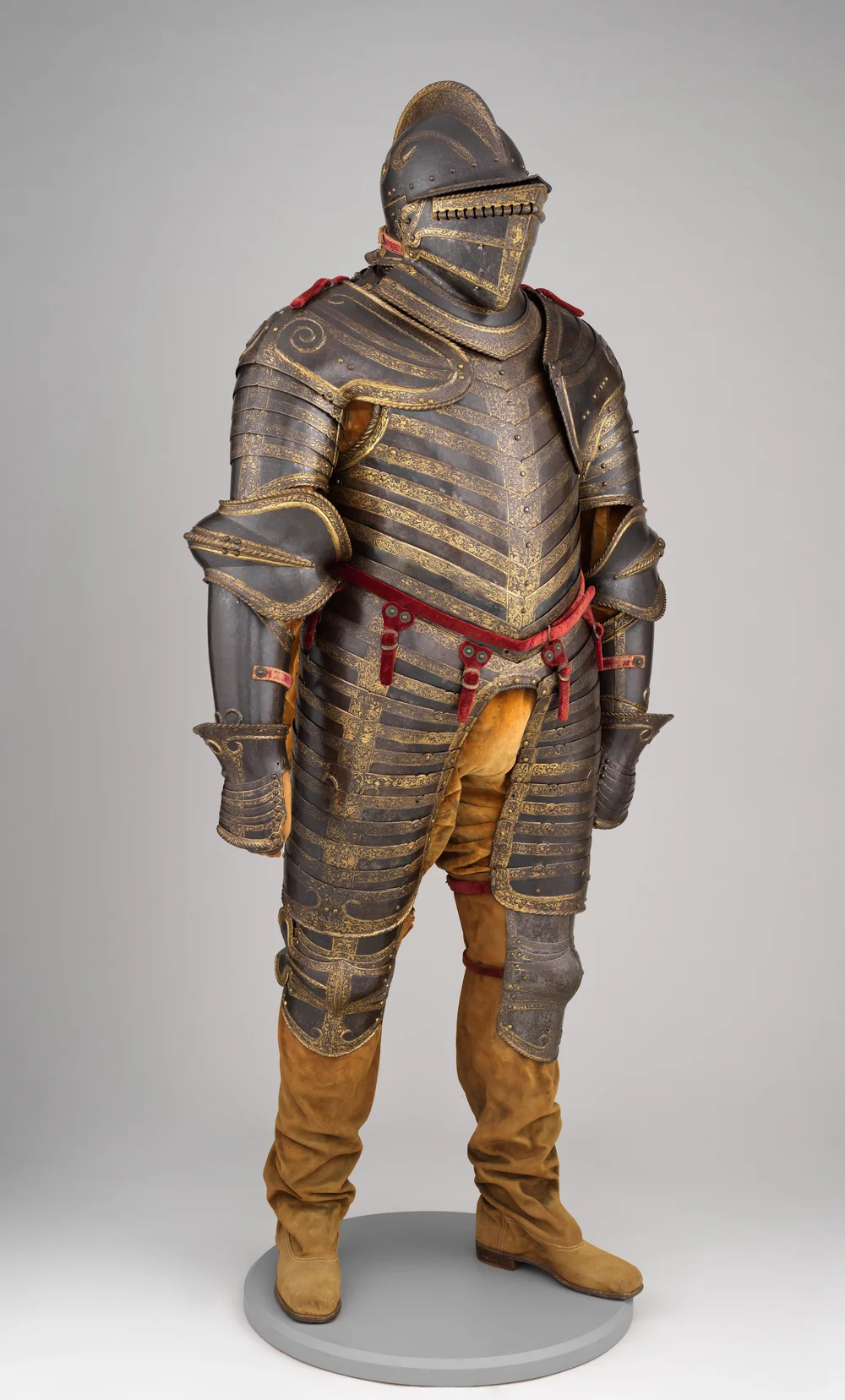 An ornate sixteenth-century suit of field armor, displayed upright against a neutral background.